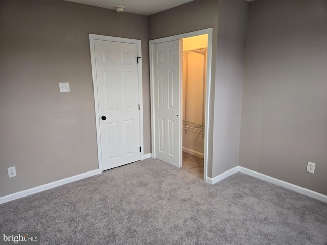 unfurnished bedroom featuring a closet and light carpet