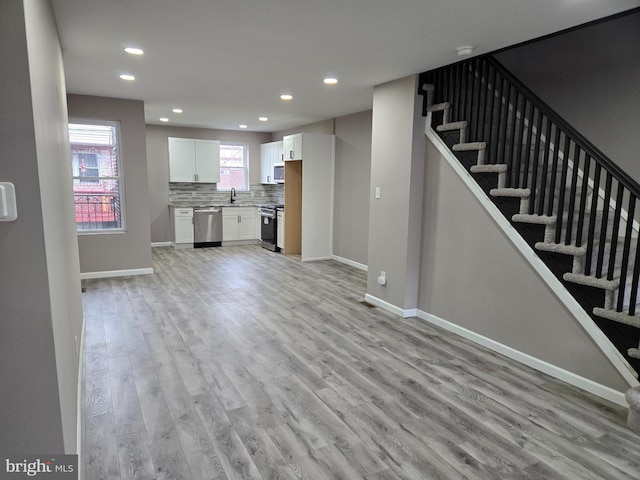 unfurnished living room featuring sink and light wood-type flooring