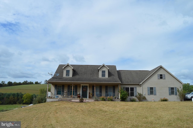 new england style home featuring a front yard and covered porch