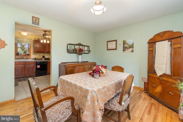 dining area with light wood-type flooring, sink, and ceiling fan