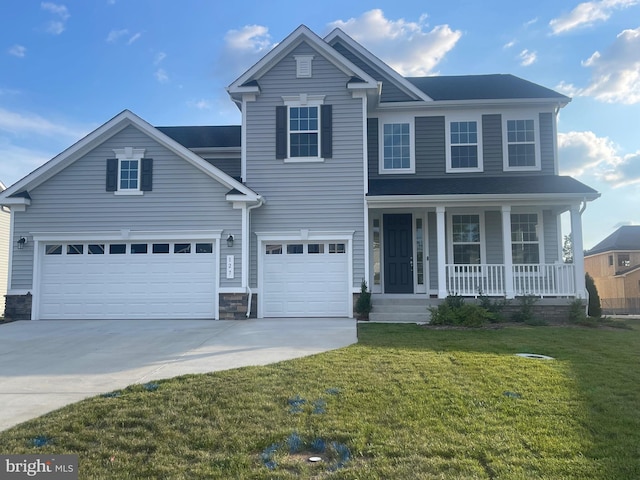 view of front of property featuring a garage, a front lawn, and a porch