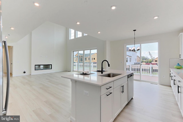 kitchen featuring an inviting chandelier, an island with sink, plenty of natural light, and sink