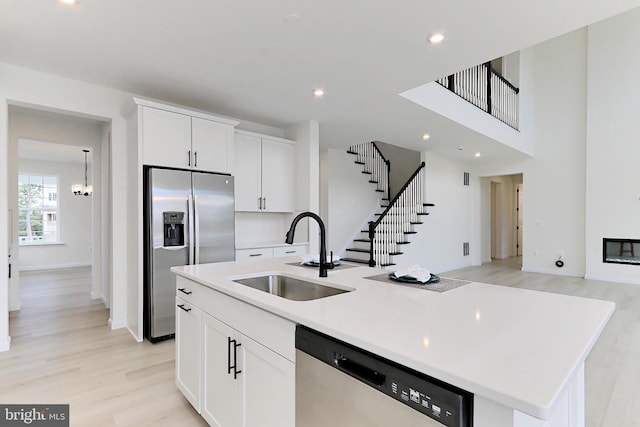 kitchen featuring a center island with sink, white cabinetry, sink, and stainless steel appliances