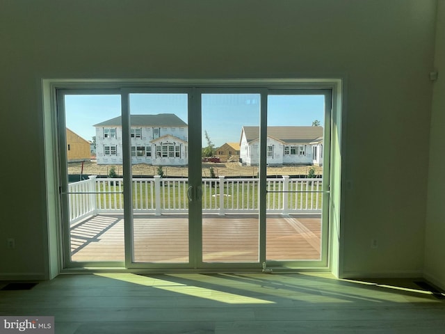 doorway to outside with light hardwood / wood-style flooring and a healthy amount of sunlight