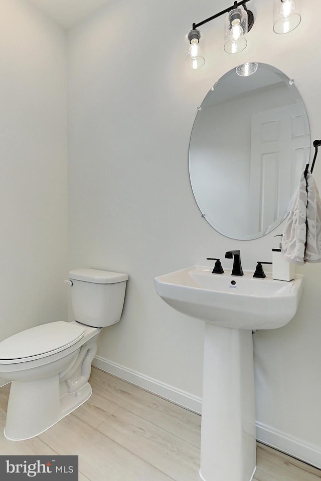 bathroom with hardwood / wood-style flooring, sink, and toilet