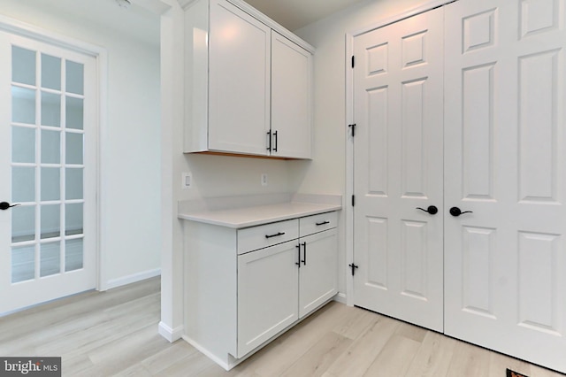 kitchen with light hardwood / wood-style flooring and white cabinets