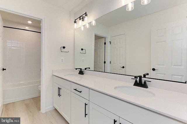 full bathroom featuring shower / bathtub combination, hardwood / wood-style floors, vanity, and toilet