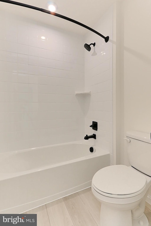 bathroom featuring toilet and tiled shower / bath