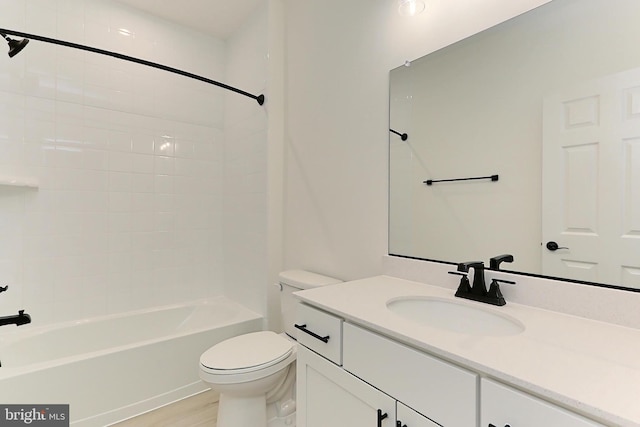 full bathroom featuring hardwood / wood-style floors, vanity, toilet, and tiled shower / bath