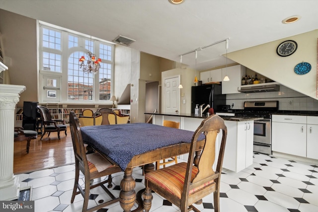 dining room with rail lighting, visible vents, and light floors