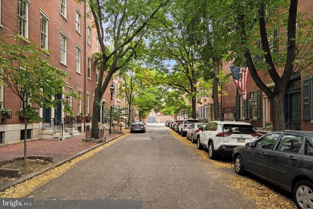 view of road featuring street lights and sidewalks