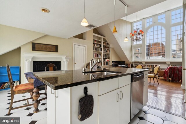kitchen with open floor plan, built in shelves, a sink, visible vents, and dishwasher