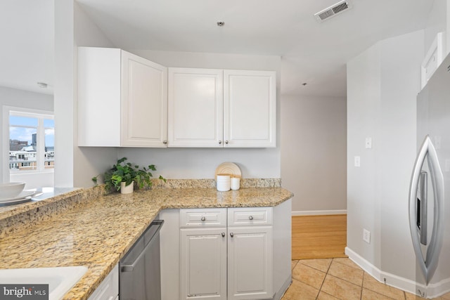 kitchen with light hardwood / wood-style flooring, light stone countertops, appliances with stainless steel finishes, and white cabinets