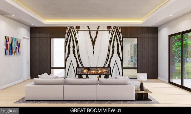 living room featuring a raised ceiling, light hardwood / wood-style flooring, and wooden walls