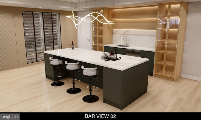 wine cellar featuring sink and light hardwood / wood-style flooring