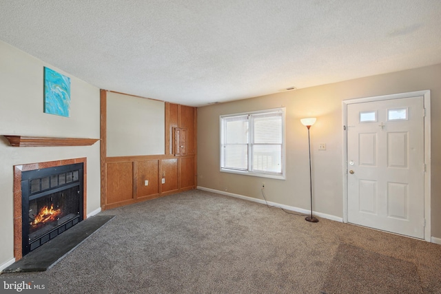 unfurnished living room with carpet and a textured ceiling