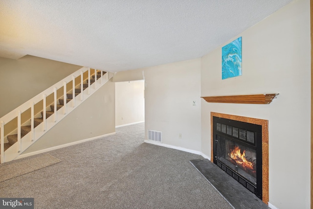 unfurnished living room with a textured ceiling and dark carpet