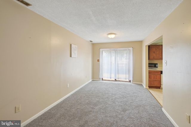 carpeted spare room with a textured ceiling