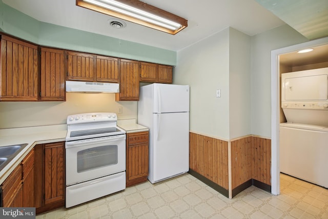 kitchen with white appliances, stacked washer / drying machine, and sink