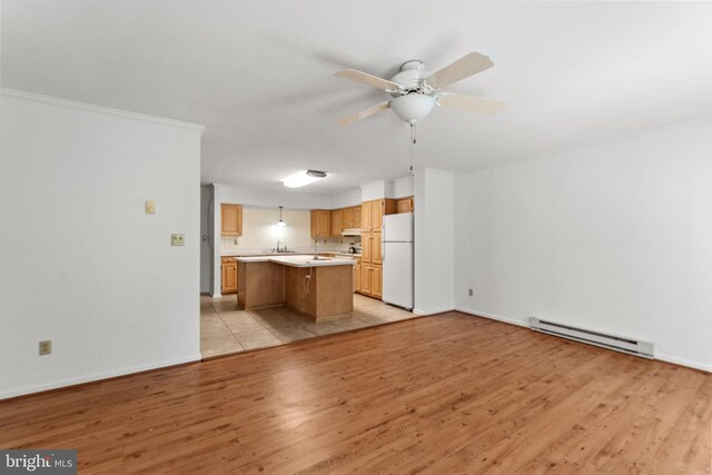 unfurnished living room with ornamental molding, baseboard heating, light hardwood / wood-style flooring, and ceiling fan