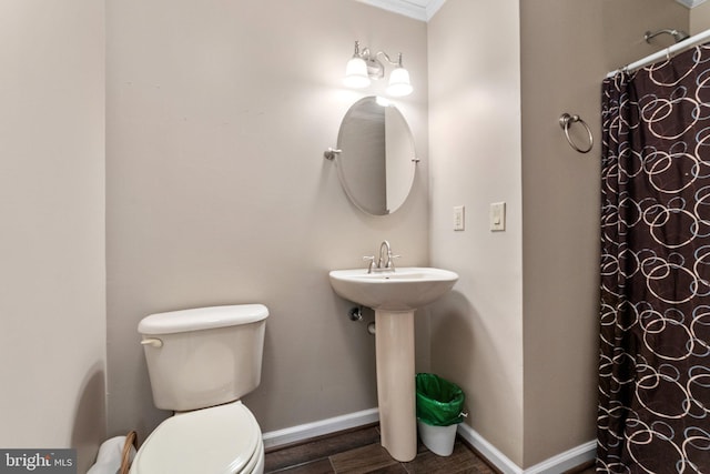 bathroom with crown molding, toilet, a shower with shower curtain, and hardwood / wood-style floors