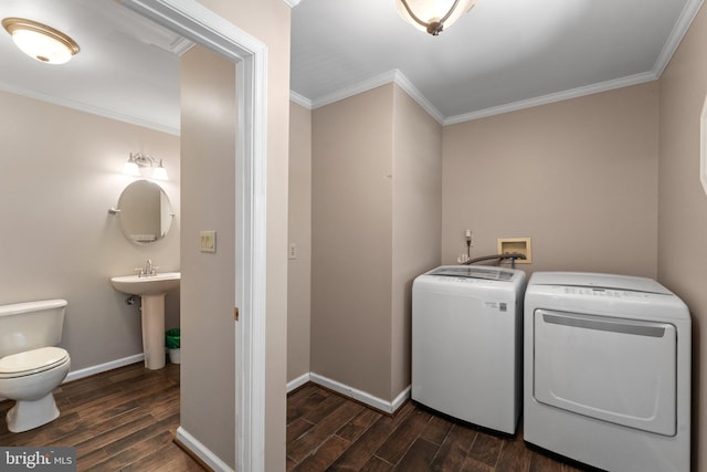 laundry area featuring ornamental molding, independent washer and dryer, sink, and dark hardwood / wood-style floors