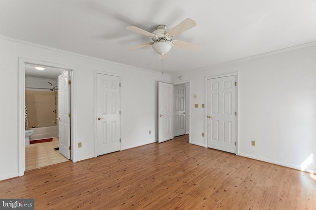 unfurnished bedroom with light hardwood / wood-style flooring, ensuite bathroom, ornamental molding, two closets, and ceiling fan