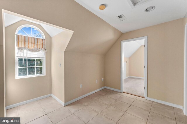 bonus room featuring lofted ceiling and light tile patterned floors