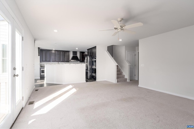 unfurnished living room with carpet flooring and ceiling fan