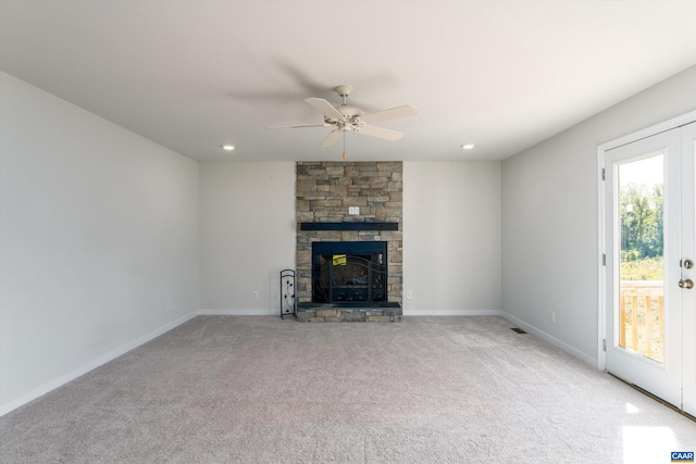 unfurnished living room featuring light colored carpet, ceiling fan, and a fireplace