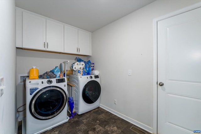 laundry area featuring separate washer and dryer and cabinets