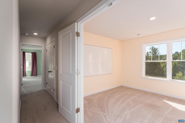 hallway featuring light colored carpet