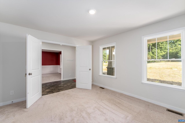 empty room with plenty of natural light and carpet floors