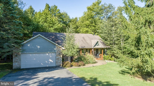 view of front of property featuring covered porch, a front yard, and a garage