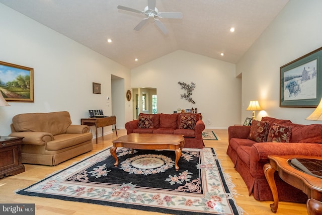 living room with light hardwood / wood-style floors, ceiling fan, and high vaulted ceiling