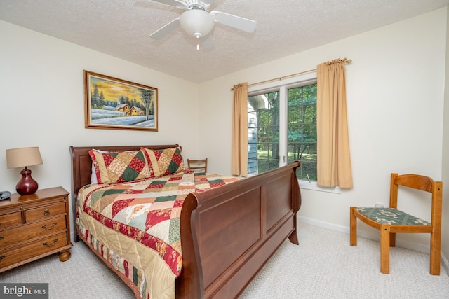 bedroom with ceiling fan, a textured ceiling, and light carpet