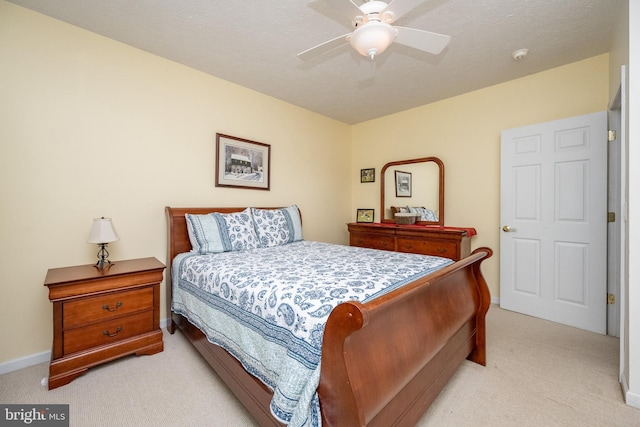 carpeted bedroom with ceiling fan and a textured ceiling