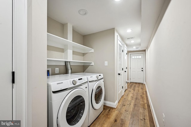 laundry room with light hardwood / wood-style flooring and washer and clothes dryer