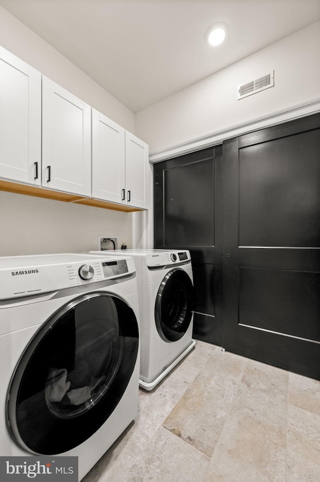 washroom featuring cabinets and washer and dryer