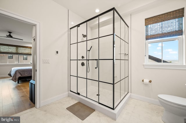 bathroom with ceiling fan, a shower with door, hardwood / wood-style floors, and toilet