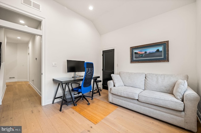 home office with wood-type flooring and vaulted ceiling