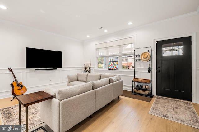 living room with light hardwood / wood-style flooring and crown molding