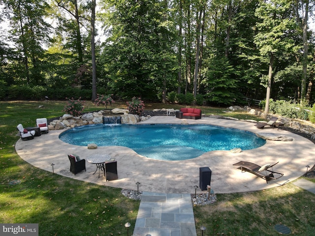 view of swimming pool featuring a patio, pool water feature, and a yard