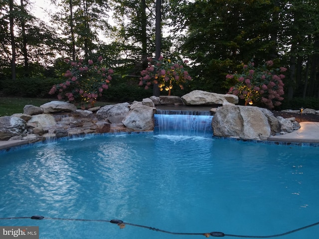 view of swimming pool with pool water feature