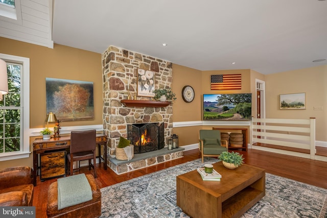 living room with a wealth of natural light, a fireplace, and hardwood / wood-style floors