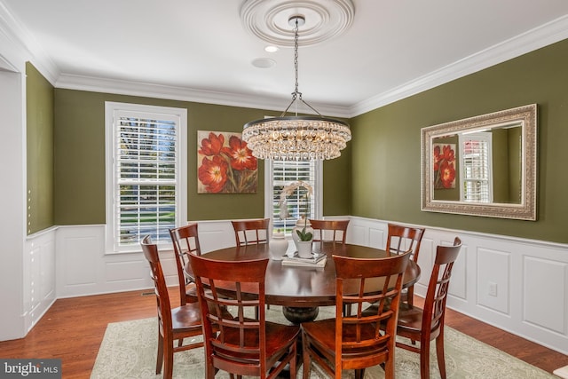 dining space featuring crown molding, a notable chandelier, and wood-type flooring