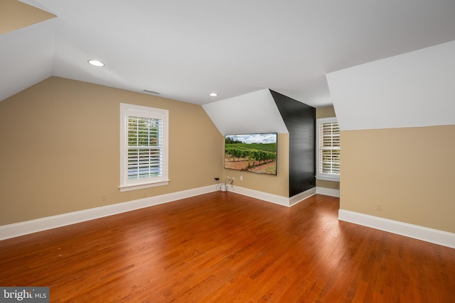 additional living space featuring lofted ceiling and hardwood / wood-style floors