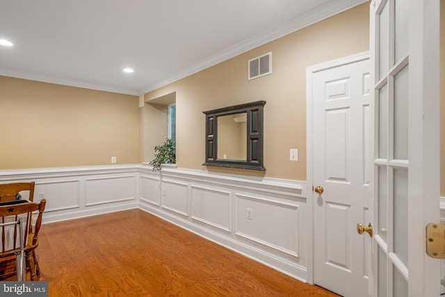 empty room with light hardwood / wood-style floors and crown molding