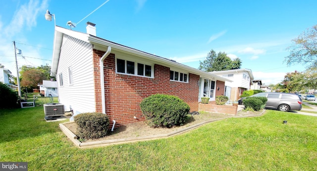 view of front facade featuring cooling unit and a front lawn