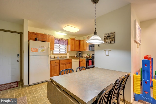 kitchen with kitchen peninsula, sink, decorative light fixtures, and black appliances